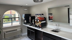 A modern kitchen with a large island, a sink, and a window with a view of the outside. - Palace Inn I-45 & Bellfort (Houston)