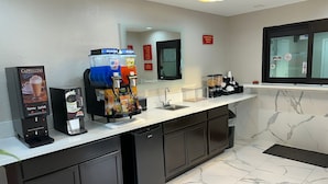 A modern kitchen with a coffee machine, a sink, and a mirror. - Palace Inn I-45 & Bellfort (Houston)