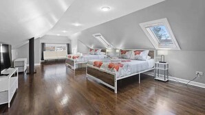 A modern bedroom with two beds, skylights, and a large window. - Bungalow w/ Game Room | LCP Collection (Morton Grove)