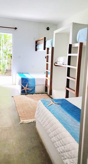 A room with bunk beds, a small shelf, a starfish decoration, and a beach-themed pillow. - Ocean access waterfront home with TIKI Ranch and Pool. Pet friendly! (Taxisco)