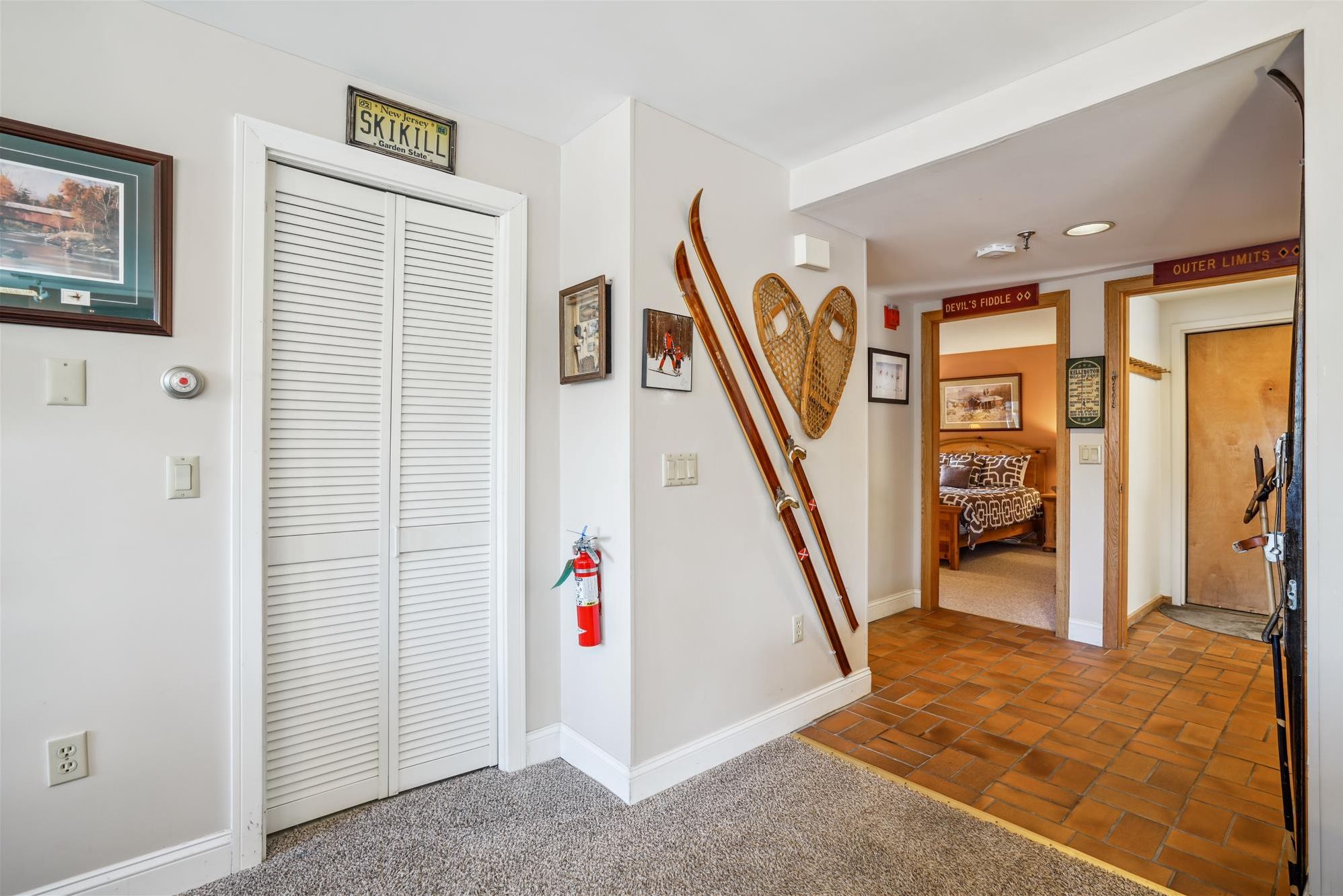 In-Unit Laundry & Ski Lodge Details - Convenient in-unit washer and dryer plus vintage ski décor add both function and mountain character throughout the hallway.