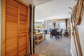 Relax in this open-plan living area with a dining space, featuring a dining table and chairs, a chandelier, and framed pictures on the walls.