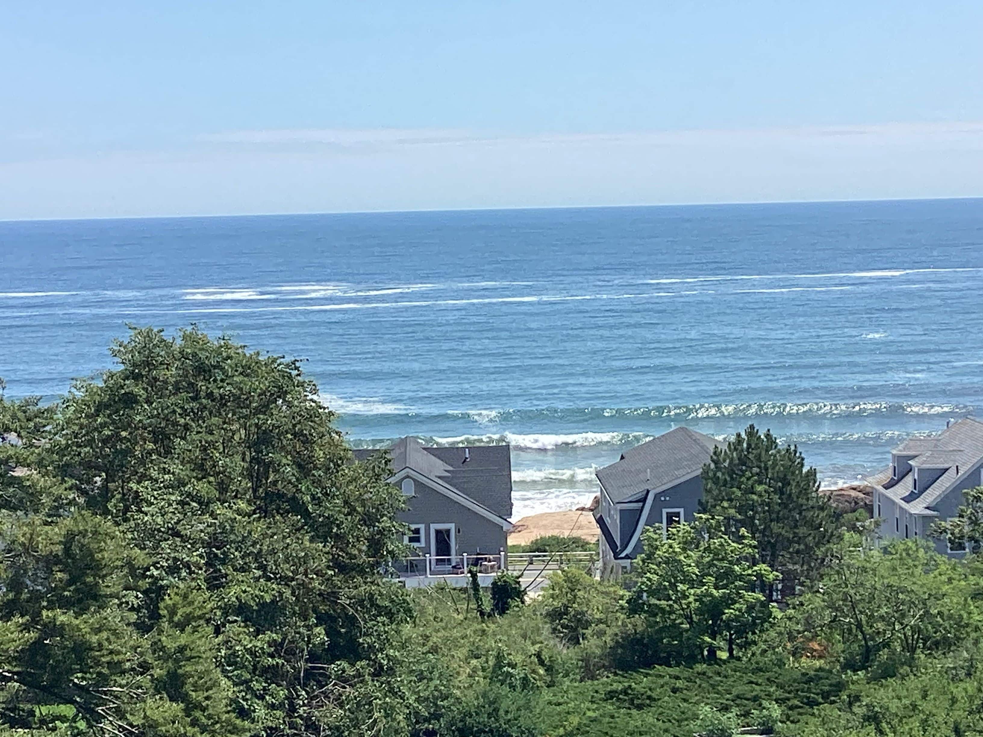 A coastal view with houses and ocean waves.