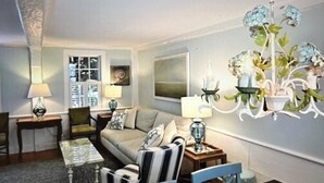 Ein Wohnzimmer mit Sofa, Sesseln, einem Couchtisch, Lampen und einem Kronleuchter.