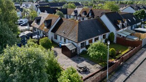 A residential area with houses featuring pitched roofs and a mix of white and dark-colored exteriors. - Braeriach by Interhome (Aviemore)