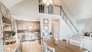 Une cuisine spacieuse avec un coin repas, un escalier et un salon.