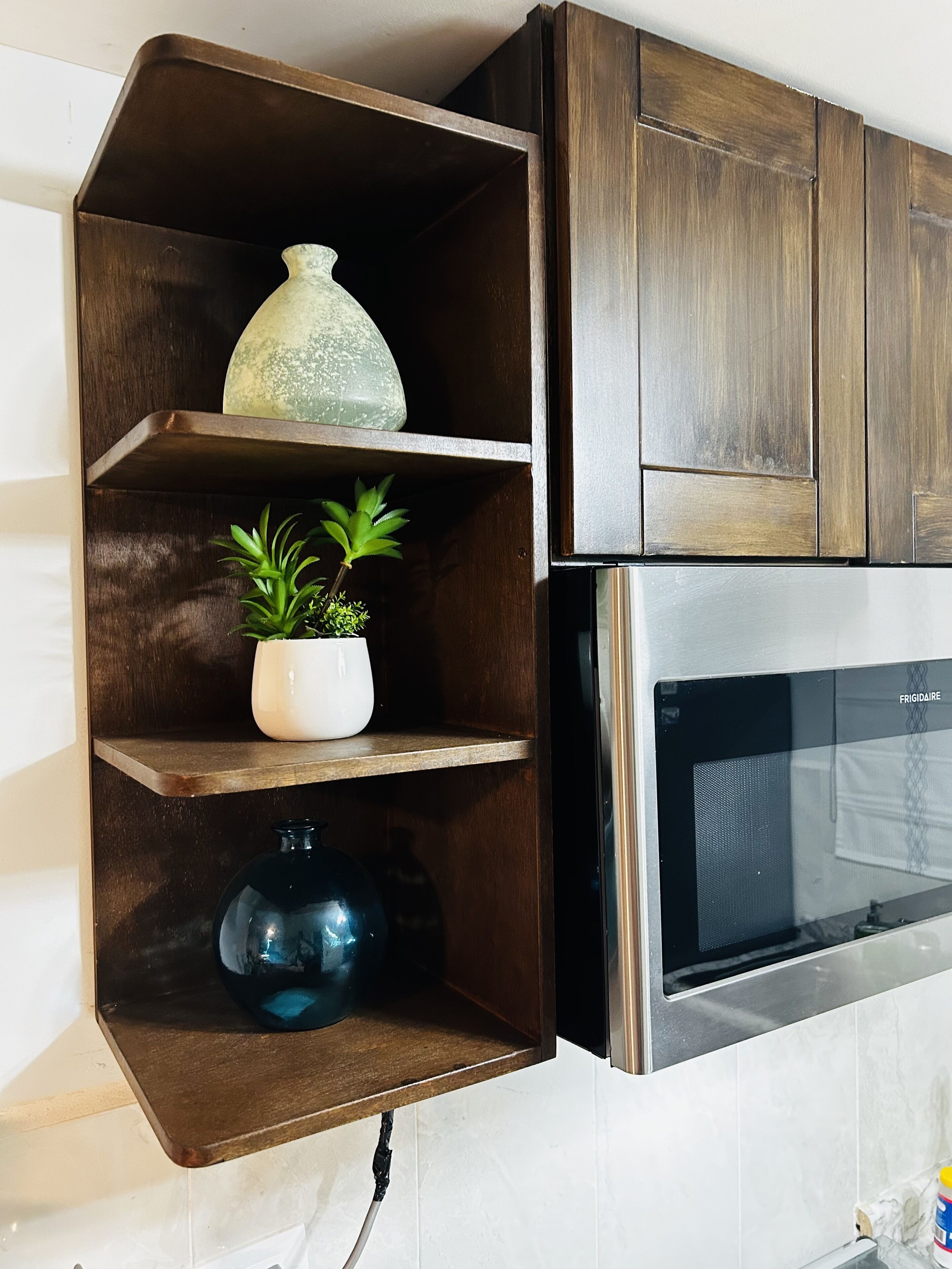 A kitchen with wooden cabinetry, a white tiled backsplash, and a stainless steel oven.