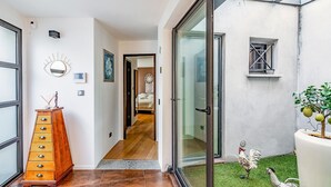 Un intérieur moderne avec une commode en bois, un attrape-rêves et une statue de coq.