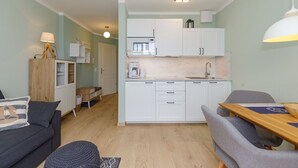 A compact living space with a kitchenette, a dining area, and a seating area.