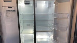 Un réfrigérateur à deux portes, doté de plusieurs étagères et d’un compartiment congélateur.