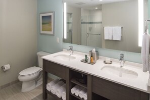 A modern bathroom with two sinks, a toilet, a shower, and a large mirror. - Ocean 22 HGV Luxury Suite on the Beach (Myrtle Beach)