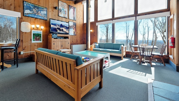 A cozy room with a wooden bench, a pool table, and a television.