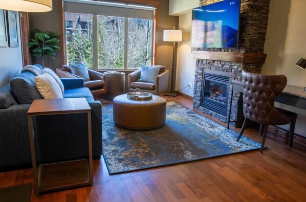 Suite romántica | Área de sala de estar | Smart TV de 55 pulgadas con canales por cable y chimenea 