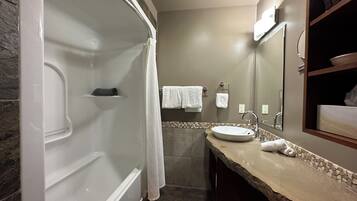 A modern bathroom with a bathtub, a sink, and a mirror.