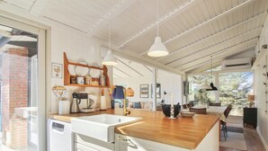 A modern kitchen with white cabinetry, a wooden countertop, and pendant lighting. - "Tuukka" - 350m from the sea by Interhome (Løkken)