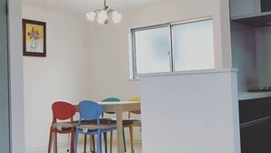 Un coin repas avec une table, des chaises et une fenêtre.