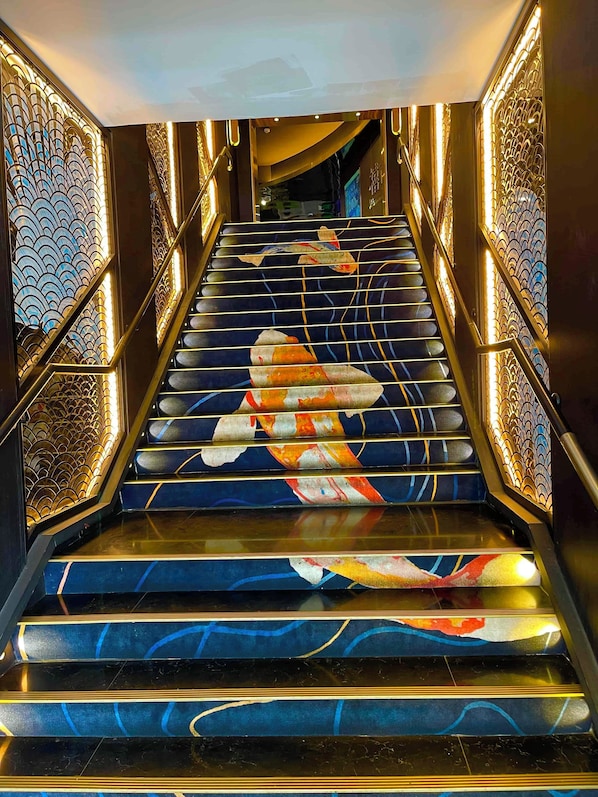 A staircase with a decorative design featuring a koi fish pattern.