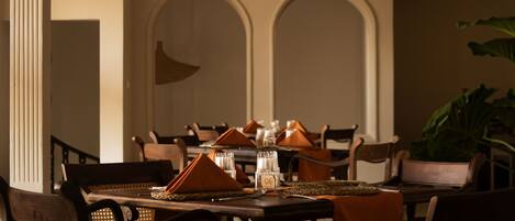 A dining area with a round table, chairs, and a ceiling fan.