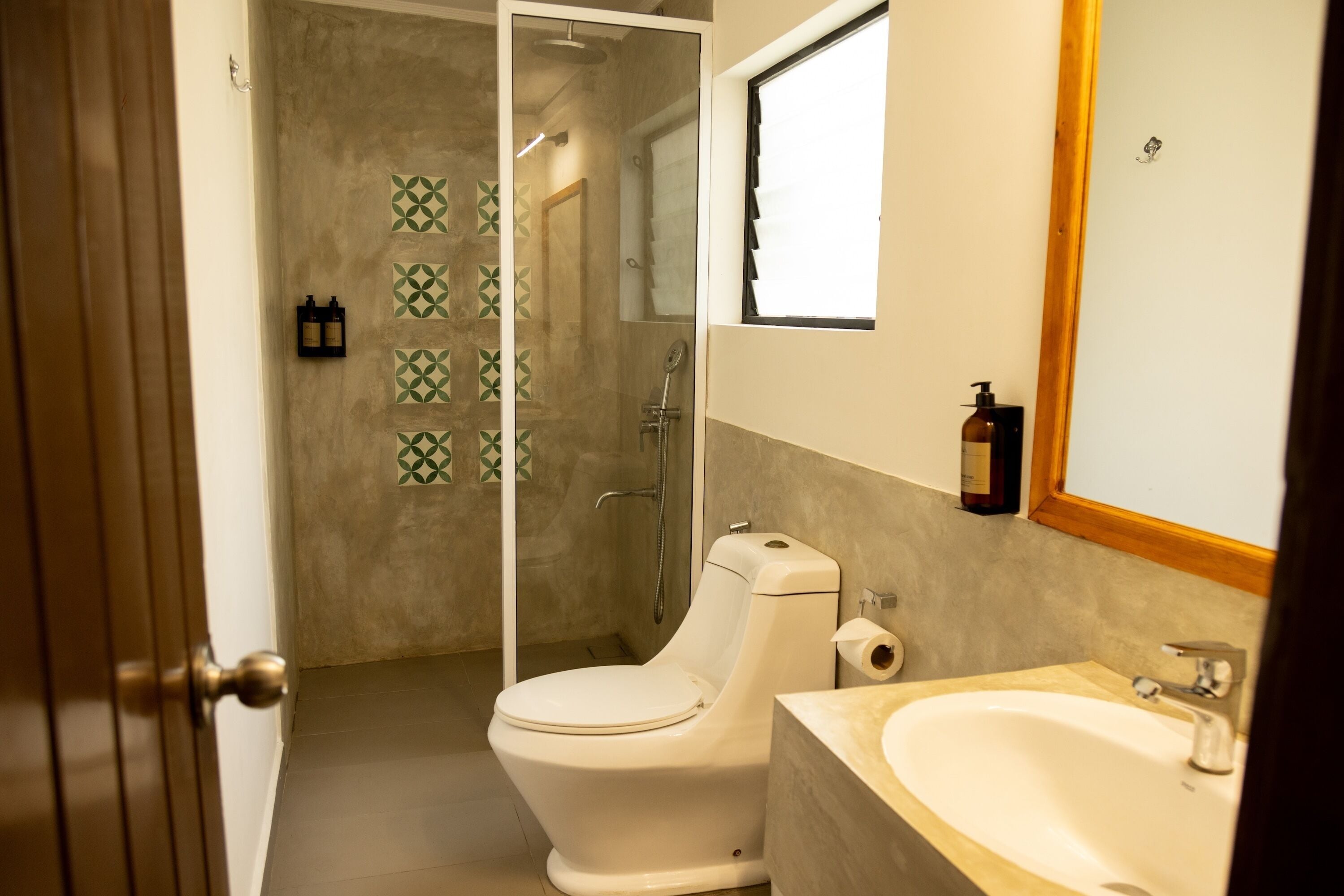 Ein Badezimmer mit Toilette, Dusche, Waschbecken und Spiegel.