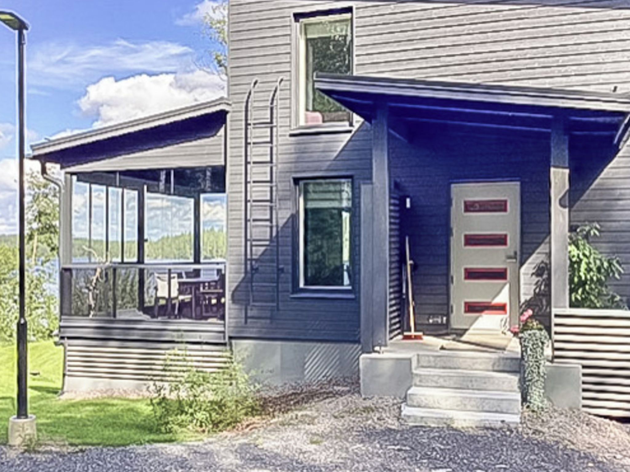 A modern two-story house with a covered porch, a front door, and a small front yard.