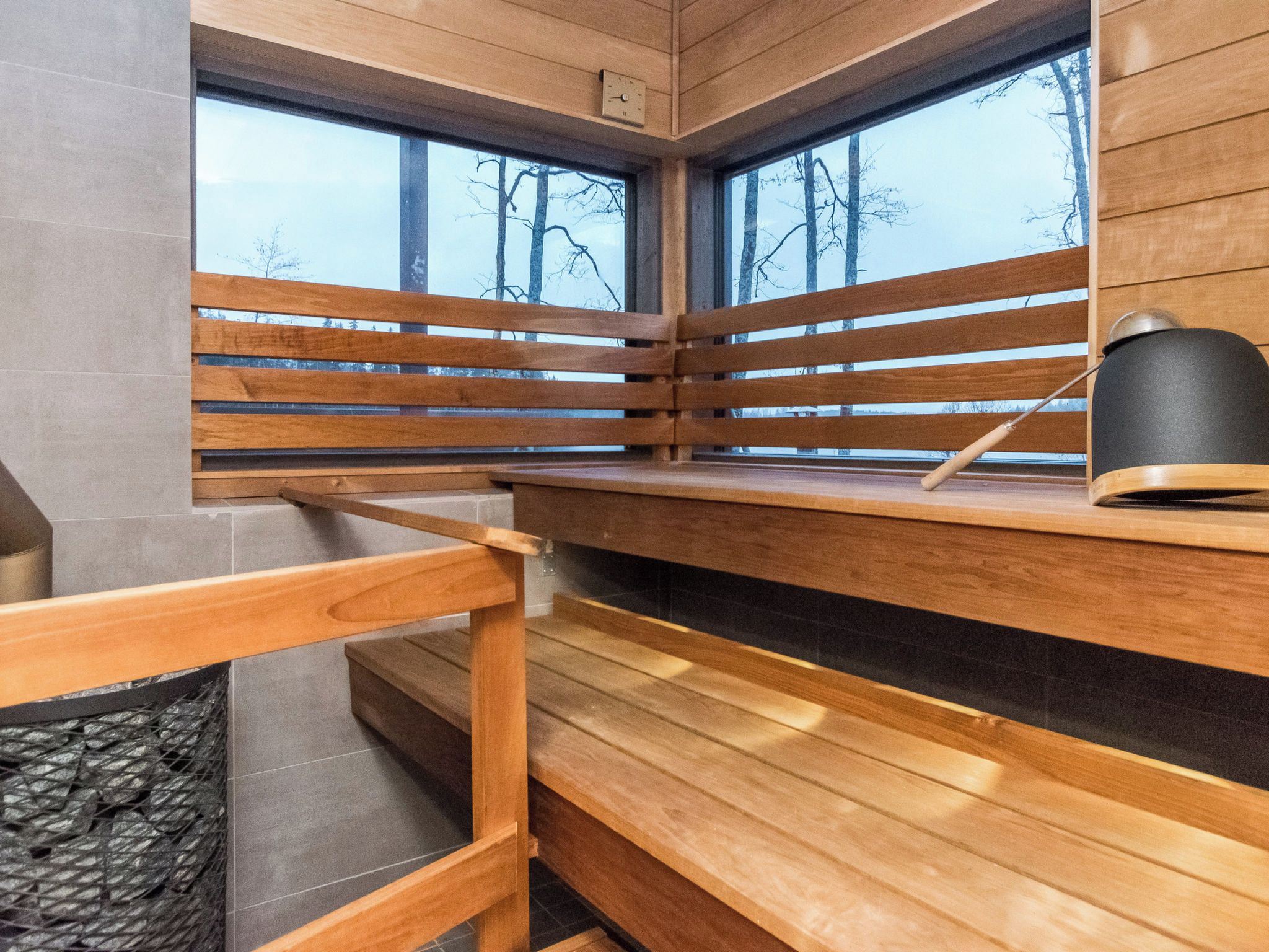 Un intérieur moderne avec des lambris en bois, un banc et une lampe noire posée sur une étagère.
