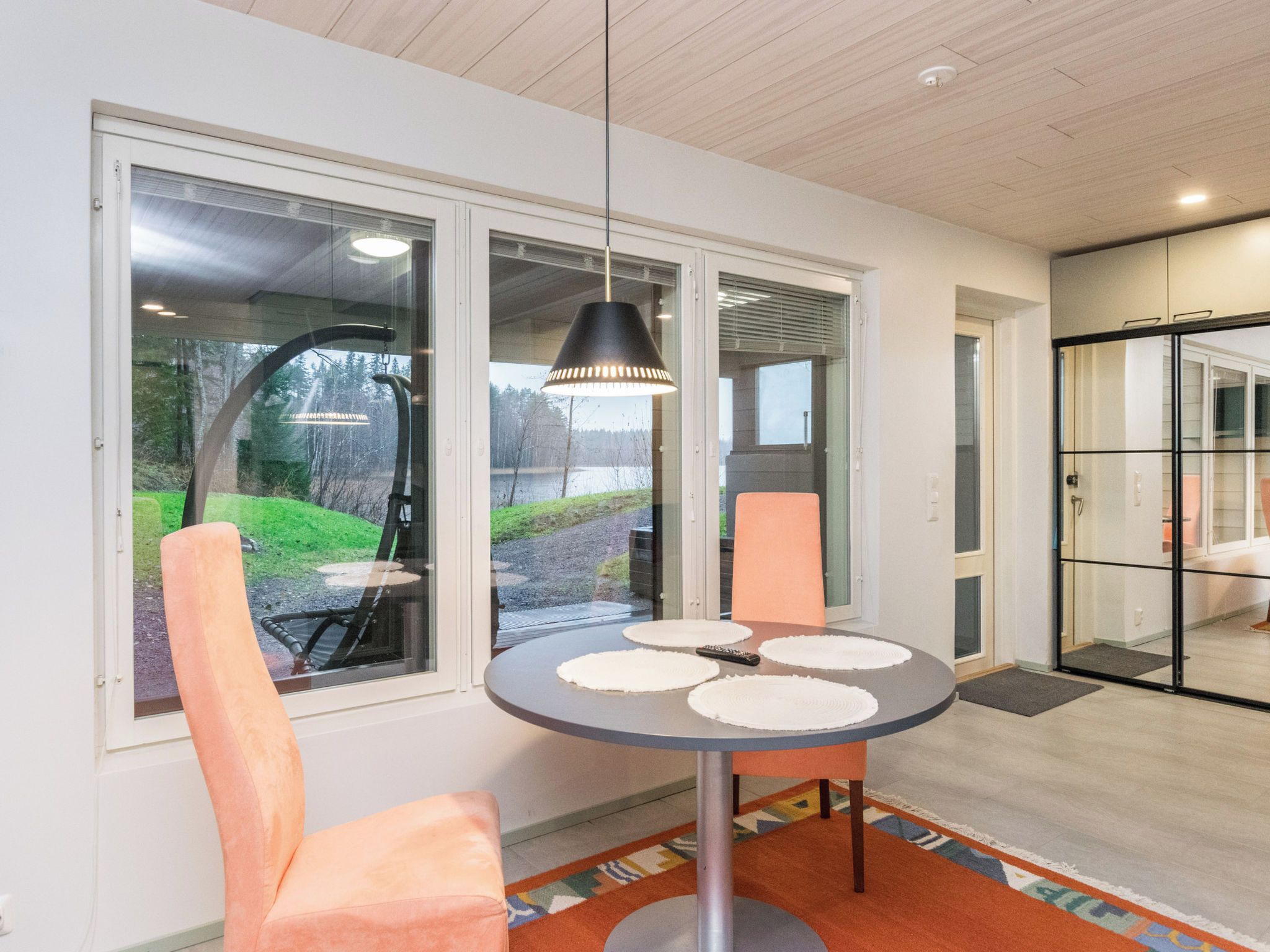 Een moderne eethoek met een ronde tafel, twee stoelen en een hanglamp.