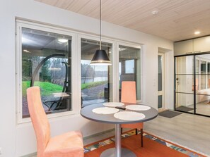 A modern dining area with a round table, two chairs, and a pendant light. - Käkikello by Interhome (Mikkeli)