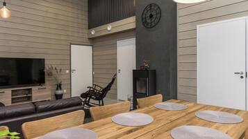 A modern dining area with a wooden table, grey placemats, and a black chair.