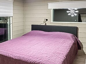 A bedroom with a bed, a window with a snowflake decoration, and a white wall. - Käkikello by Interhome (Mikkeli)