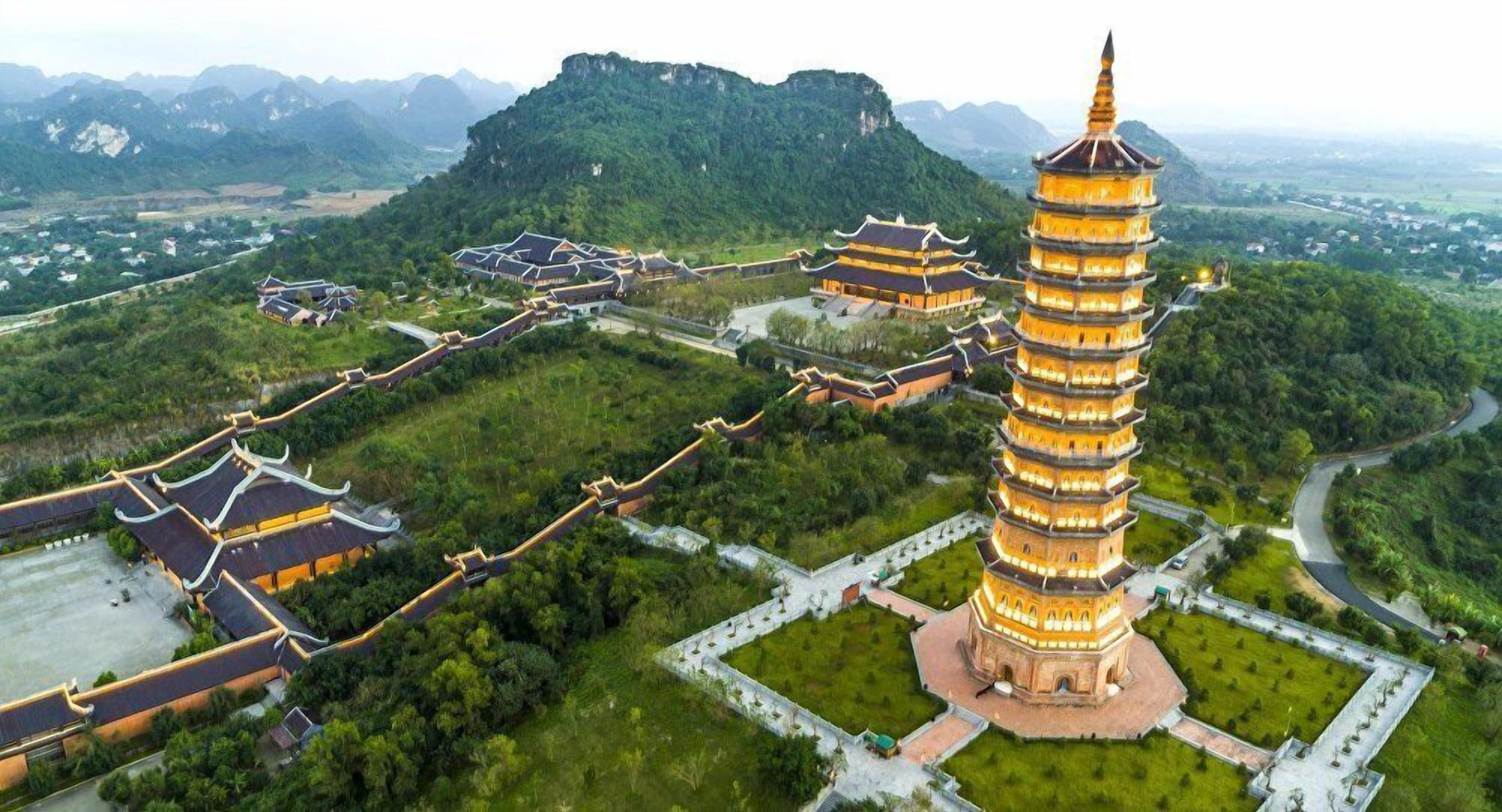 A pagoda surrounded by traditional buildings and lush greenery.