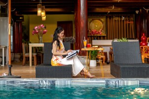 Una piscina al aire libre, sombrillas, sillones reclinables de piscina