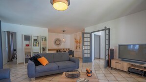 Un salon moderne avec un canapé, un téléviseur et un espace ouvert.