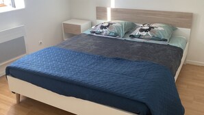 A bedroom with a bed, nightstands, and a window. - Bel et Spacieux Appartement (Rives)