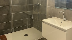 A modern bathroom with a glass shower enclosure, a white sink, and a mirror. - Bel et Spacieux Appartement (Rives)