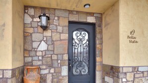 A stone facade with a black ornate door, a potted plant, and a sign reading "Bella Vista". - Luxury Downtown Rental (Hot Tub/Pet Friendly) #9 (Moab)