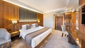 A modern hotel room with a large bed, a desk, and a TV. - E hotel (Madinah)