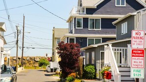 A residential street with houses, a 'NO PARKING THIS SIDE OF STREET' sign, and a 'PERMIT PARKING' sign with a $125 fine. - Sea Bright Beach House Sleeps 6 Perfect for a Family with little ones! (Sea Bright)