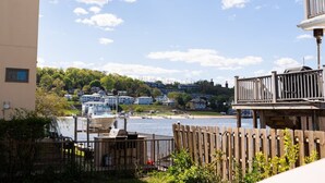 A waterfront property with a wooden deck, a barbecue area, and a view of boats and houses across the water. - Sea Bright Beach House Sleeps 6 Perfect for a Family with little ones! (Sea Bright)
