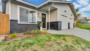 A modern two-story house with a garage, a large window, and a well-maintained front yard.