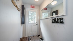 A hallway with an exit sign, a door, a mirror, and a 'CAFE' sign on the wall. - Starlight Shores - Serene Lakefront Retreat: Explore and Unwind (Miller Lake)