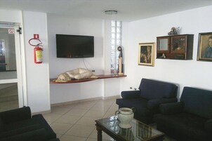 Una sala de estar con televisor, sofá, mesa de centro y chimenea.