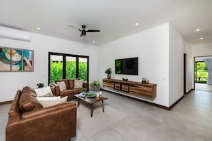 A modern living room with a sofa, coffee table, and a TV mounted on the wall.