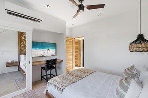 A bedroom with a bed, a desk, a chair, a ceiling fan, and a painting on the wall. - Villa Blanca (Las Brisas, Hacienda Pinilla)
