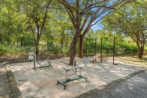 Un'area fitness all'aperto con panchine e attrezzature.