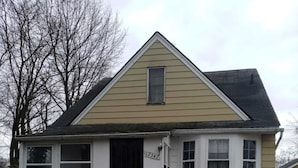 A two-story house with a front porch, a black door, and a number '17347' on the wall. - Super Comfy Room at a Great Location  (Detroit)
