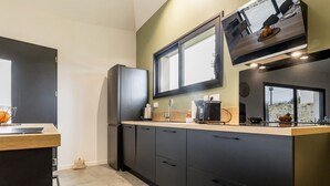 Eine moderne Küche mit dunklen Schränken, einem eingebauten Backofen und einem Fenster über der Spüle.