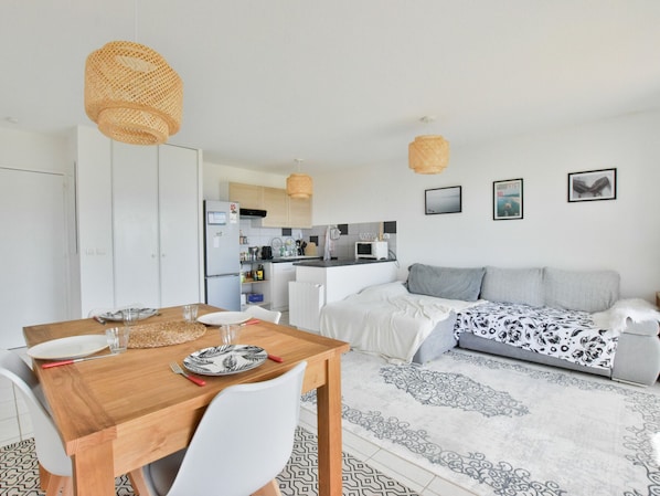 A compact living space with a dining area, kitchenette, and a sofa.