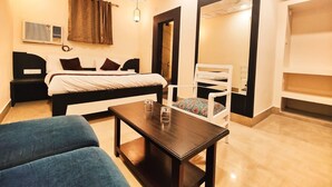 Un dormitorio con cama, mesita de noche, silla y espejo.