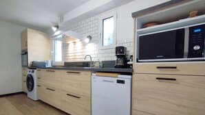 Une cuisine moderne équipée d’un lave-vaisselle, d’un four à micro-ondes et d’une machine à café.