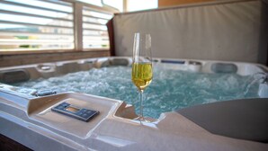 Ein Whirlpool mit einem Weinglas und einer Bedienkonsole.